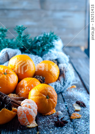 Tangerine in scarf over wooden background Tangerine in scarf over wooden background 19251418