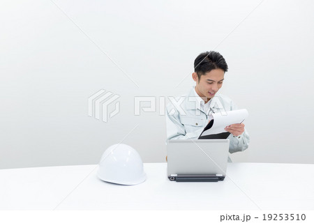 事務所で記録を確認する作業員 19253510
