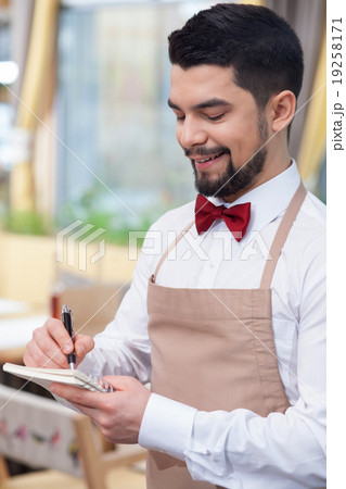 Attractive young waiter is receiving an order Attractive young waiter is receiving an order 19258171