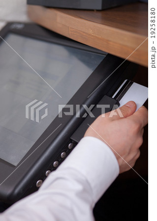 Skillful young cashier is receiving payment for 19258180