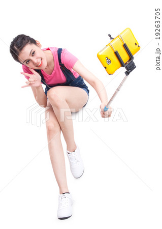 woman taking picture with smartphone selfie stick 19263705