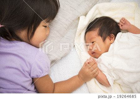 生まれたばかりの弟と対面するお姉ちゃんの写真素材