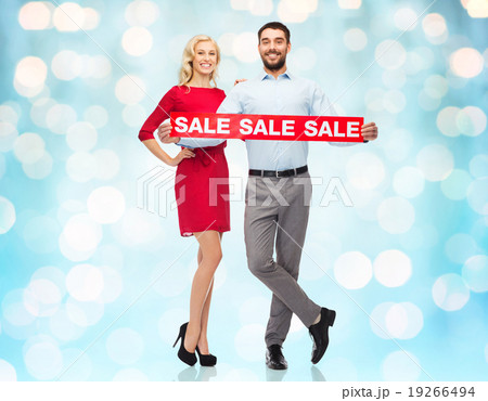 happy couple with red sale sign over blue lights happy couple with red sale sign over blue lights 19266494