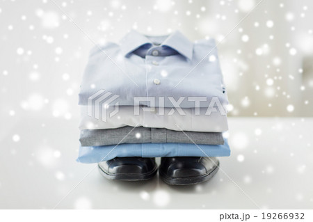 close up of folded male shirts and shoes on table close up of folded male shirts and shoes on table 19266932