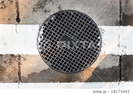 round sewer with holes and white line of the road round sewer with holes and white line of the road 19275042