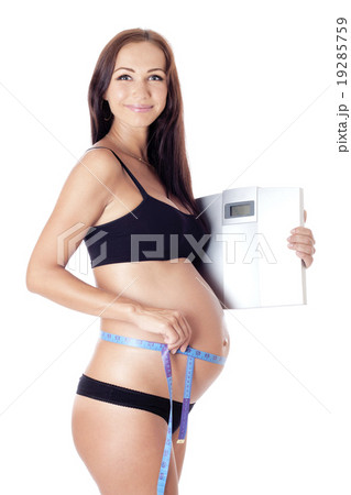 Pregnant woman  holding scales  19285759