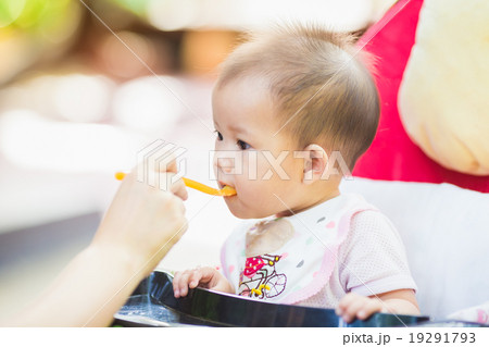 mother feeding her 7 months baby in the garden mother feeding her 7 months baby in the garden 19291793