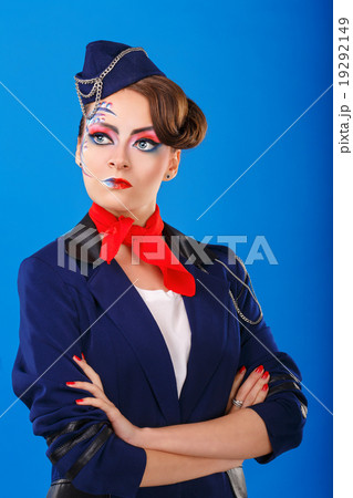 Stewardess with face art posing with folded arms. 19292149