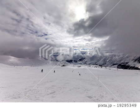 Skiers on ski slope before rain 19295349
