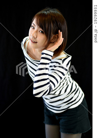 耳に手を当てて聞く女性 19299931