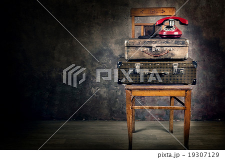 Vintage suitcase with phone on chair Vintage suitcase with phone on chair 19307129