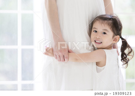 母親に抱きつく女の子の写真素材