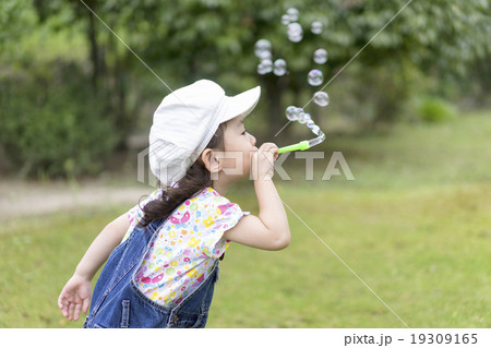 シャボン玉を吹く女の子の写真素材