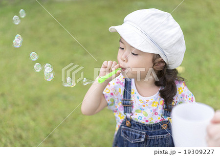 シャボン玉を吹く女の子の写真素材