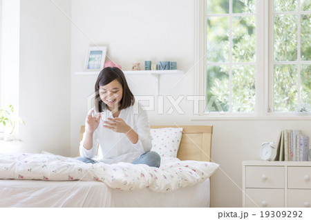 ベッドの上に座る女の子の写真素材