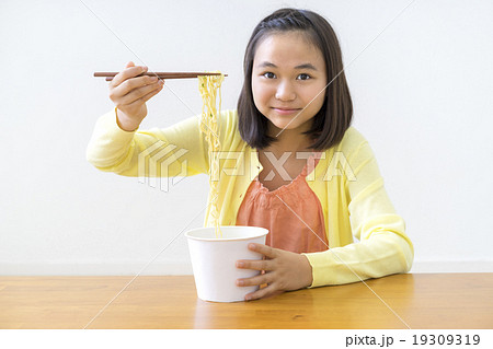 カップラーメンを食べる女の子の写真素材