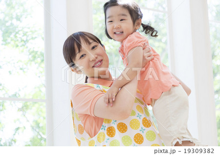 子供を抱く保育士の女性 19309382