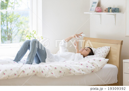 ベッドに寝そべる女の子の写真素材
