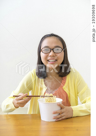 カップラーメンを食べる女の子の写真素材