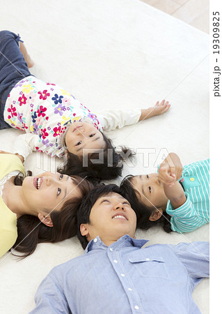 仰向けに寝転ぶ日本人家族の写真素材