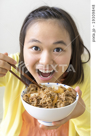 牛丼を食べる女の子の写真素材