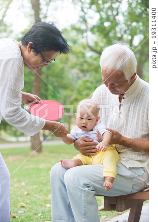chinese grandfather and grandmother playing with baby grandson a chinese grandfather and grandmother playing with baby grandson a 19311400