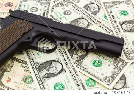 Gun on money background. 19316173