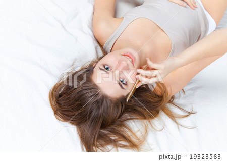 The young girl in bed with phone 19323583