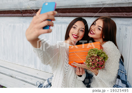Two girls make selfie with gift Two girls make selfie with gift 19325495