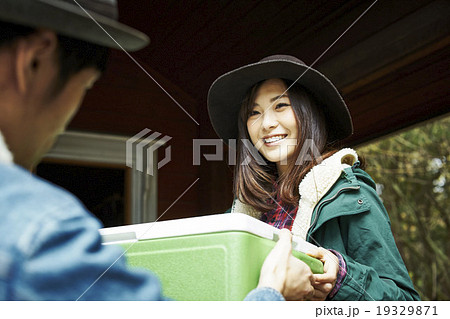 クーラーボックスを女性に手渡す男性 19329871