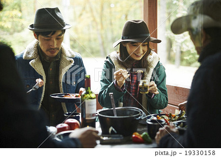 友人と食事を楽しむカップル 19330158