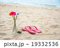 Flower and red old slippers on the beach 19332536