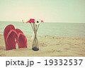 Red old slippers and flower on the beach 19332537
