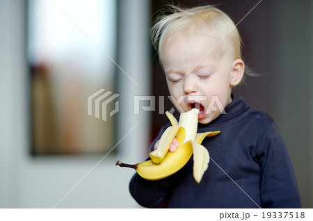 Toddler girl eating a banana Toddler girl eating a banana 19337518
