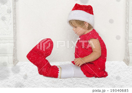 Small child in Santa suit sitting on floor with snow Small child in Santa suit sitting on floor with snow 19340685