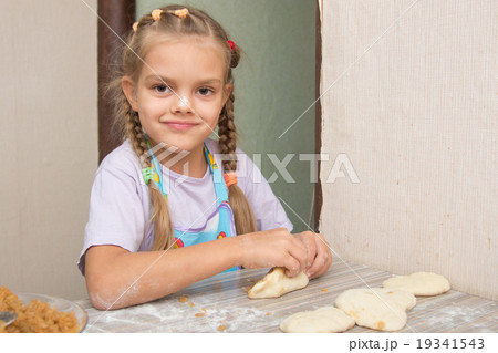 Cheerful girl sculpts cakes with cabbage Cheerful girl sculpts cakes with cabbage 19341543