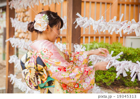 おみくじを結ぶ女性の写真素材