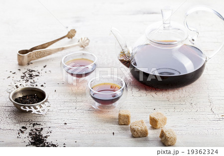 Black tea in a transparent teapot and cups 19362324