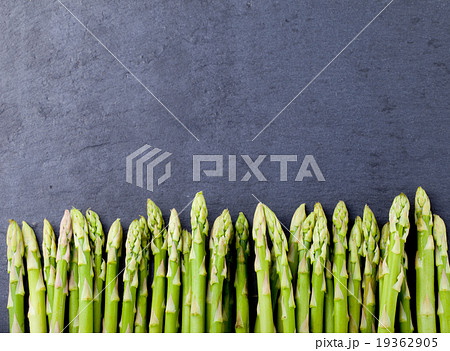 Asparagus sprouts on a black stone background. Asparagus sprouts on a black stone background. 19362905