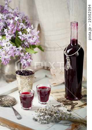 Blackcurrant homemade liquor with lilac flowers Blackcurrant homemade liquor with lilac flowers 19362994