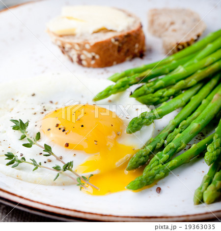 Green asparagus,fried egg and bread with butter. Green asparagus,fried egg and bread with butter. 19363035