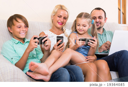 Portrait of family playing with gadgets at home 19364085