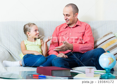 Portrait of father and little girl discussing something indoors 19364172