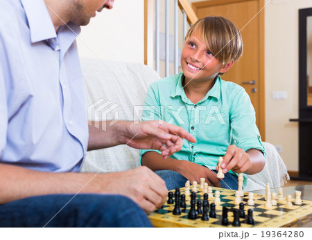 Man and teenager son playing chess. Man and teenager son playing chess. 19364280