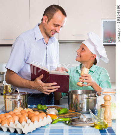 Father and teenage son cooking together. 19364290