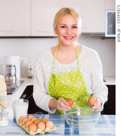 woman cracking eggs into bowl 19364872