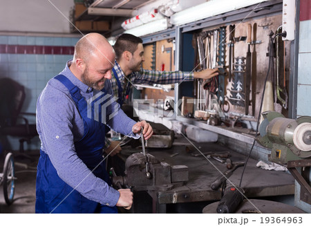 Mechanics at work in repair shop Mechanics at work in repair shop 19364963