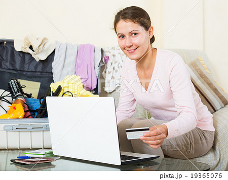 woman sitting with credit card near laptop and baggage woman sitting with credit card near laptop and baggage 19365076