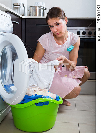 Sad woman near washing machine. Sad woman near washing machine. 19365131