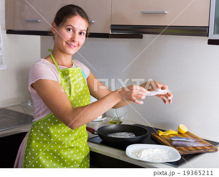 Housewife frying fish at kitchen. Housewife frying fish at kitchen. 19365211